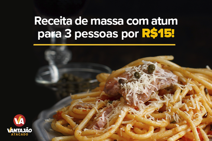 Na imagem, um prato com massa e atum está posicionado sobre uma superfície preta. A massa, espaguete, está por baixo e, no topo, pode-se ver um pedaço de atum e uma porção de queijo ralado.