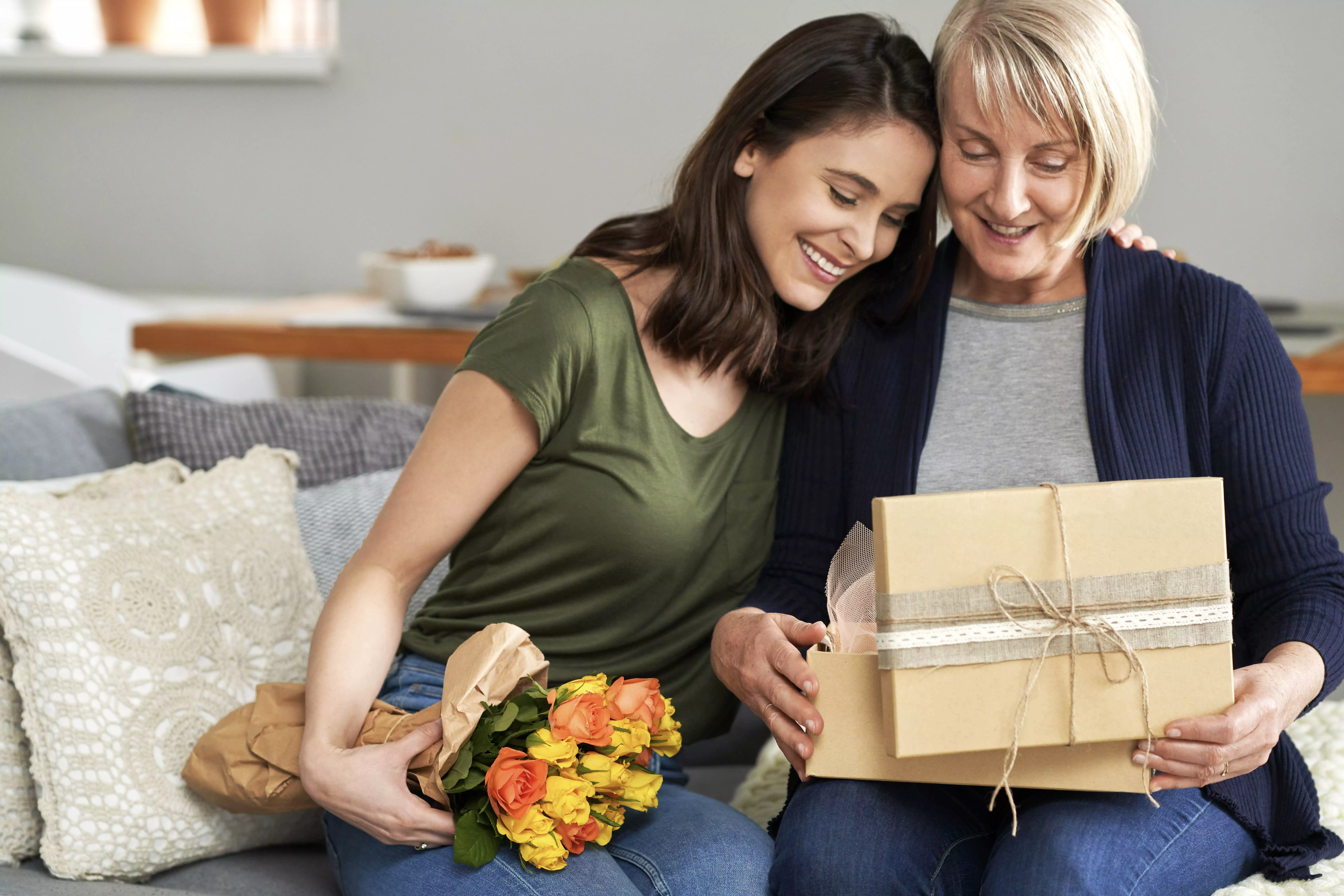 A imagem mostra duas mulheres com presentes sorrindo