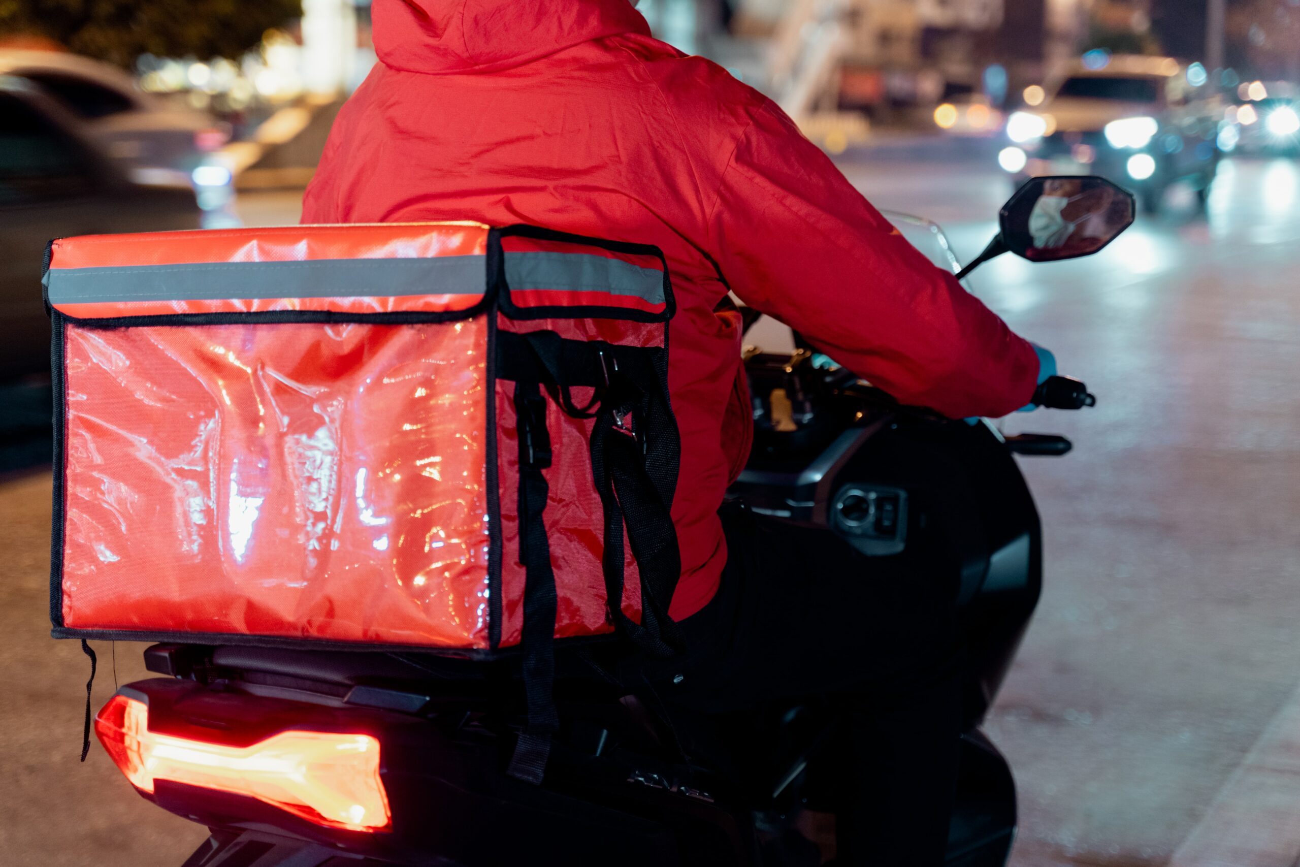 A imagem mostra um entregador de delivery em uma moto.