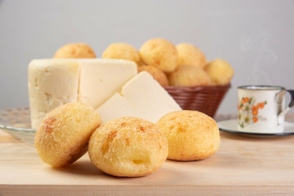 A imagem mostra pães de queijo em uma mesa.  